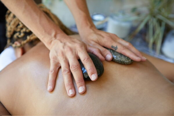 Hot stone massage being done on the client by the masseuse at cityWell