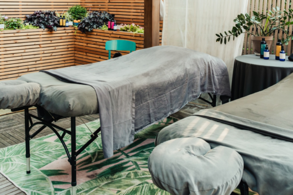 Couples massage table setup at cityWell brooklyn outdoor Pergola surrounded by greenery in Gowanus Brooklyn